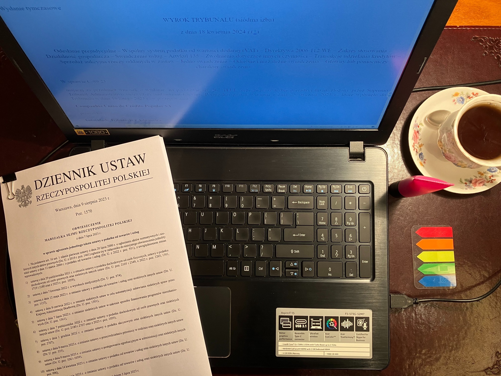 Laptop Acer z otwartym dokumentem na ekranie dotyczącym orzeczenia Trybunału Sprawiedliwości Unii Europejskiej w sprawie VAT, obok leży Dziennik Ustaw Rzeczypospolitej Polskiej z 9 sierpnia 2023 r.
