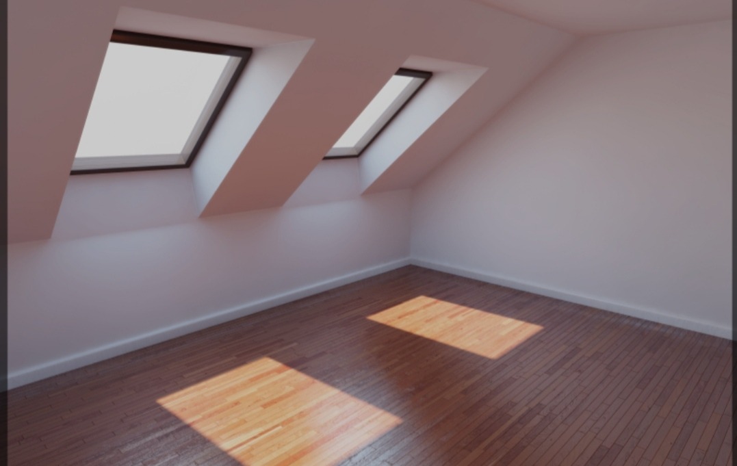 Poddasze z dwiema oknami dachowymi, parkiet ułożony wzdłuż, ściany pomalowane na biało, promienie słoneczne padające na podłogę.
