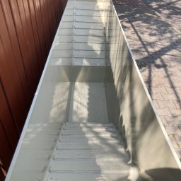 Dmytro Dumaretskui - Nowy, pusty, prostokątny zbiornik z tworzywa sztucznego, prawdopodobnie do budowy oczka wodnego lub basenu, sfotografowany z góry w Warszawie. Widoczna faktura wewnętrznych ścianek i cień drzewa...