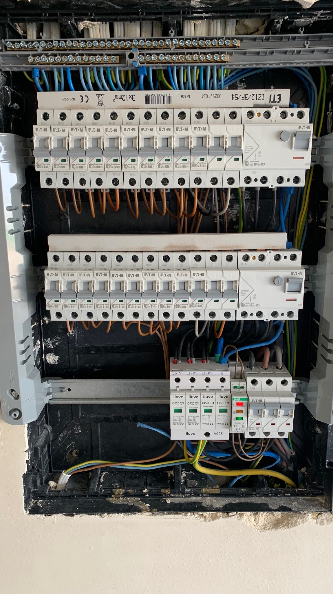 Rozdzielnia elektryczna z bezpiecznikami EATON i przewodami w skrzynce, widok z bliska. Instalacja w trakcie prac w Warszawie.