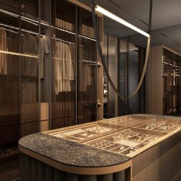 pracownia mi - Elegancka garderoba z przeszklonymi szafami i wyspą na biżuterię, oświetlona listwami LED, w odcieniach brązu i beżu. Nowoczesny design z dbałością o detale.