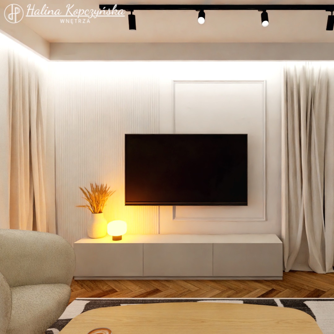 Nowoczesny salon z telewizorem na ścianie, beżowe zasłony, drewniana podłoga i dekoracyjna lampka nocna na szafce RTV.