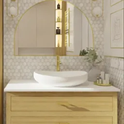 Nowoczesna łazienka z umywalką nablatową, drewnianą szafką, lustrem w złotej ramie i heksagonalnymi płytkami na ścianie.