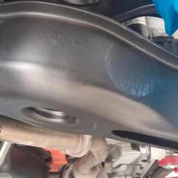 Autobezkorozji.pl - Podwozie samochodu po zabiegu antykorozyjnym w Janowie, widoczne nowe śruby i elementy zawieszenia zabezpieczone folią.