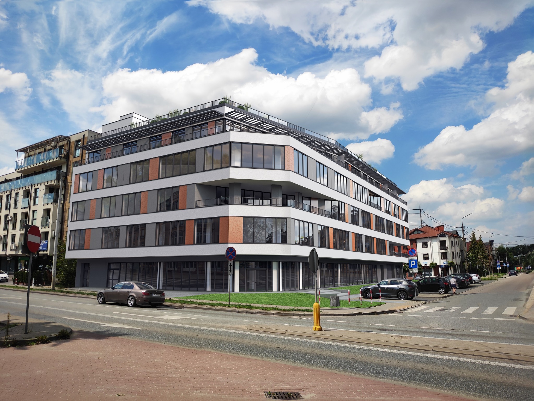 Nowoczesny budynek biurowo-mieszkalny z płaskim dachem i balkonami, widoczny z poziomu ulicy w słoneczny dzień.