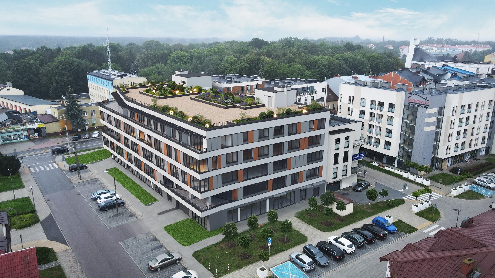 Wizualizacja zewnętrzna nowoczesnego budynku wielorodzinnego z zielonym tarasem na dachu, widok z góry na parking i otoczenie miejskie.