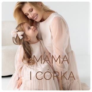 Mama i córka w dopasowanych, jasnych sukienkach, wykonanych na zamówienie w Jarosławiu. Dziewczynka ma na włosach dużą kokardę. Kobieta obejmuje córkę, patrząc na nią z uśmiechem.