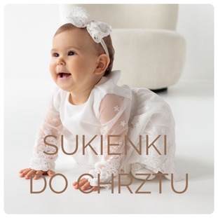 Uśmiechnięta dziewczynka raczkuje w białej sukience do chrztu z koronkowymi rękawami i opaską z kokardą na głowie, na jasnym tle.