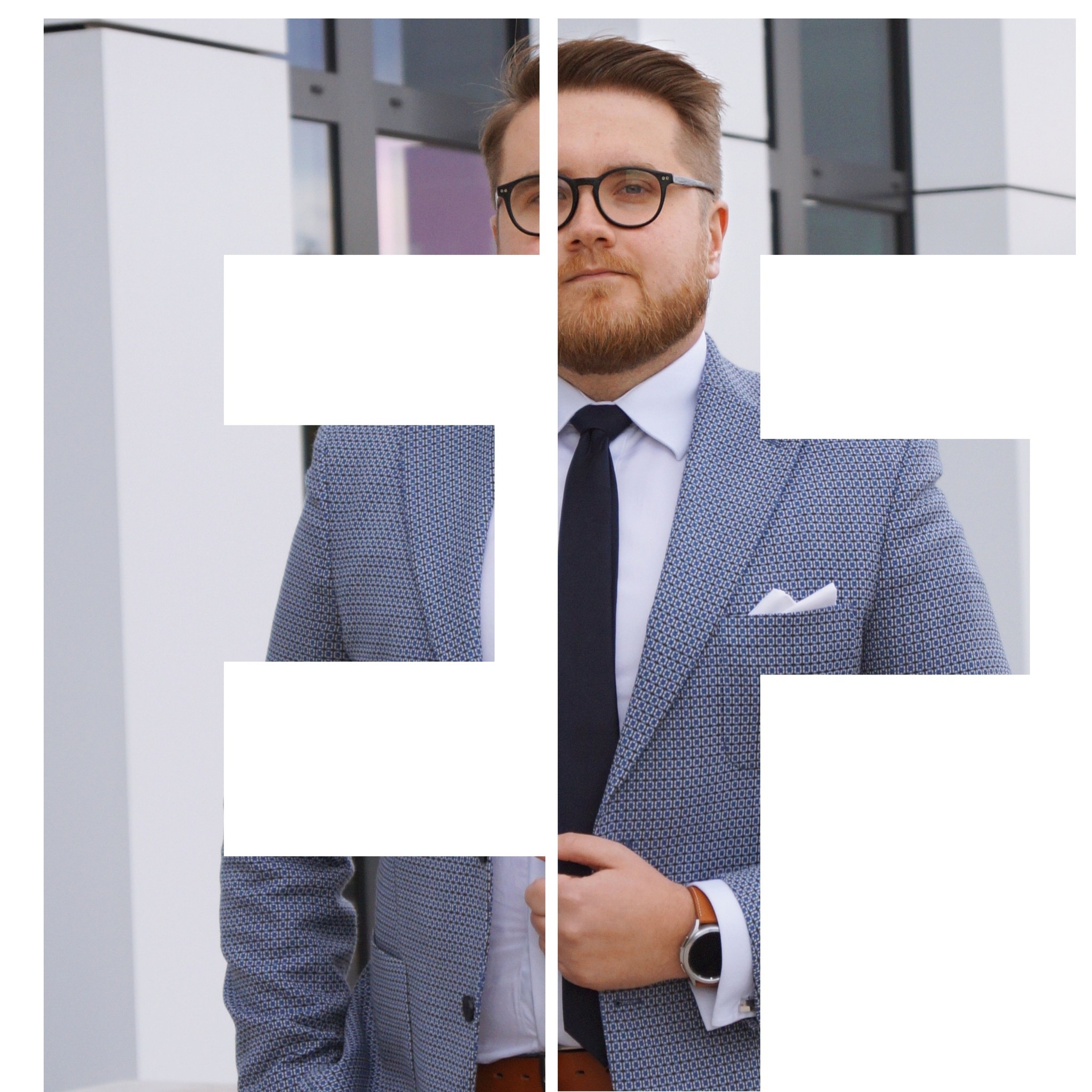 Mężczyzna w okularach i wzorzystej marynarce, z zegarkiem na ręku, stoi na tle nowoczesnego budynku. Elegancki strój sugeruje profesjonalizm i dbałość o wizerunek.