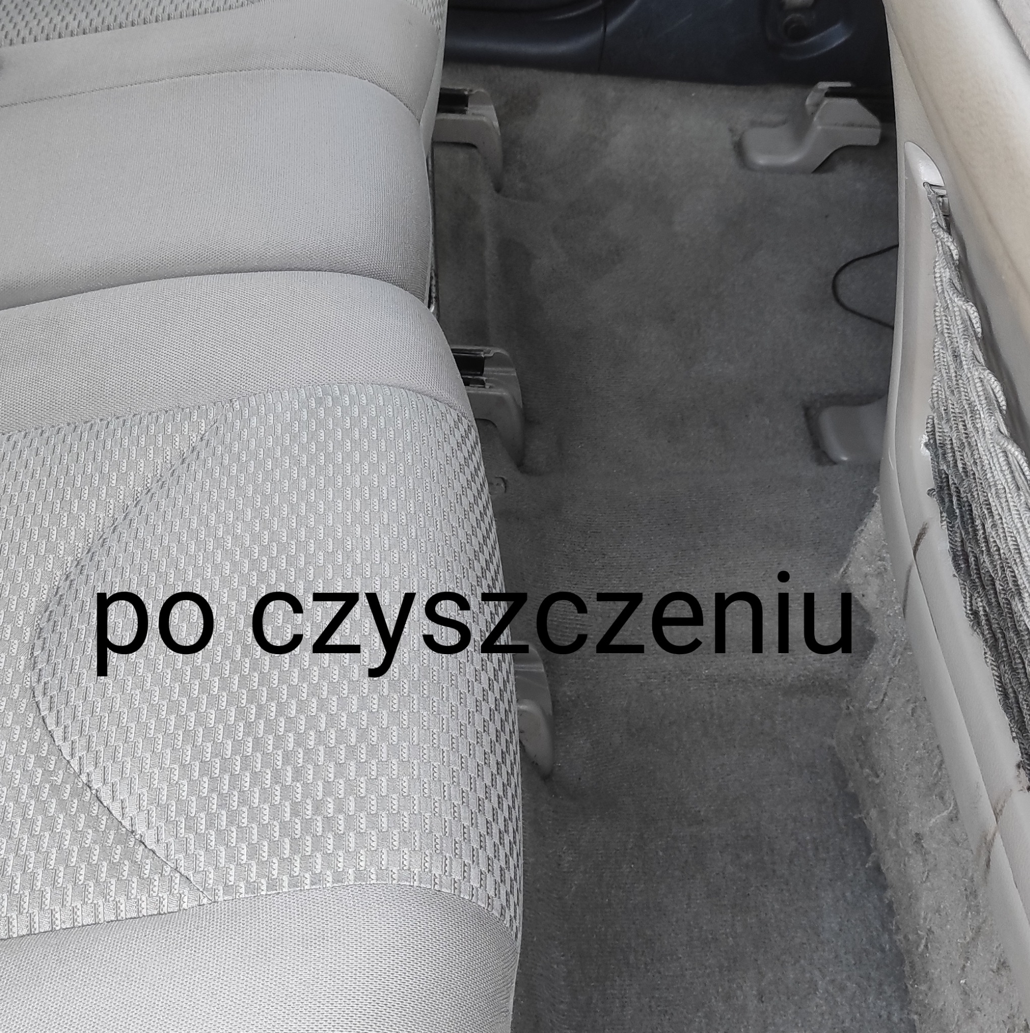 Jasnoszara tapicerka samochodowa po czyszczeniu, widoczne detale faktury materiału i fragment podłogi.