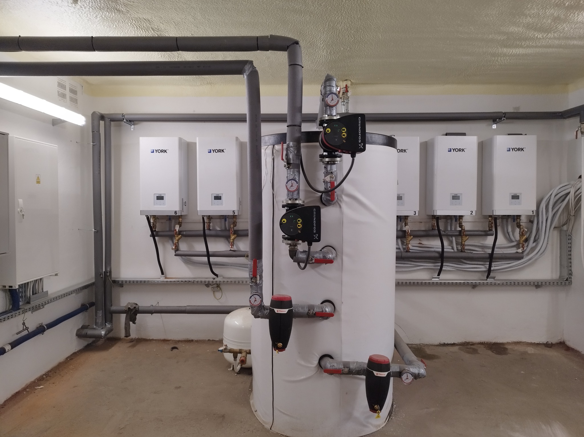 Kompleksowa instalacja grzewcza z piecami York i zbiornikiem akumulacyjnym w kotłowni, widok z przodu. Realizacja w Okalew.