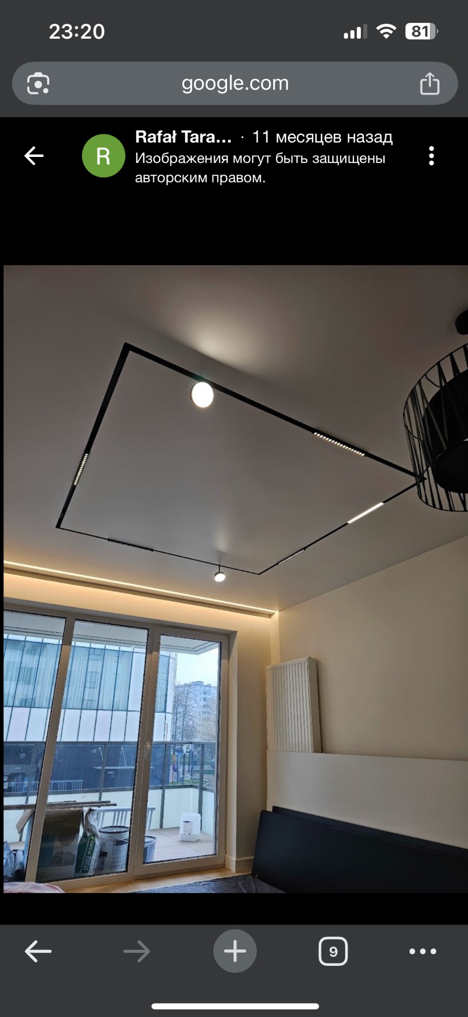 Nowoczesne oświetlenie sufitowe z czarnymi listwami i punktowymi lampami w jasnym wnętrzu. Widok na okno balkonowe i elementy dekoracyjne.