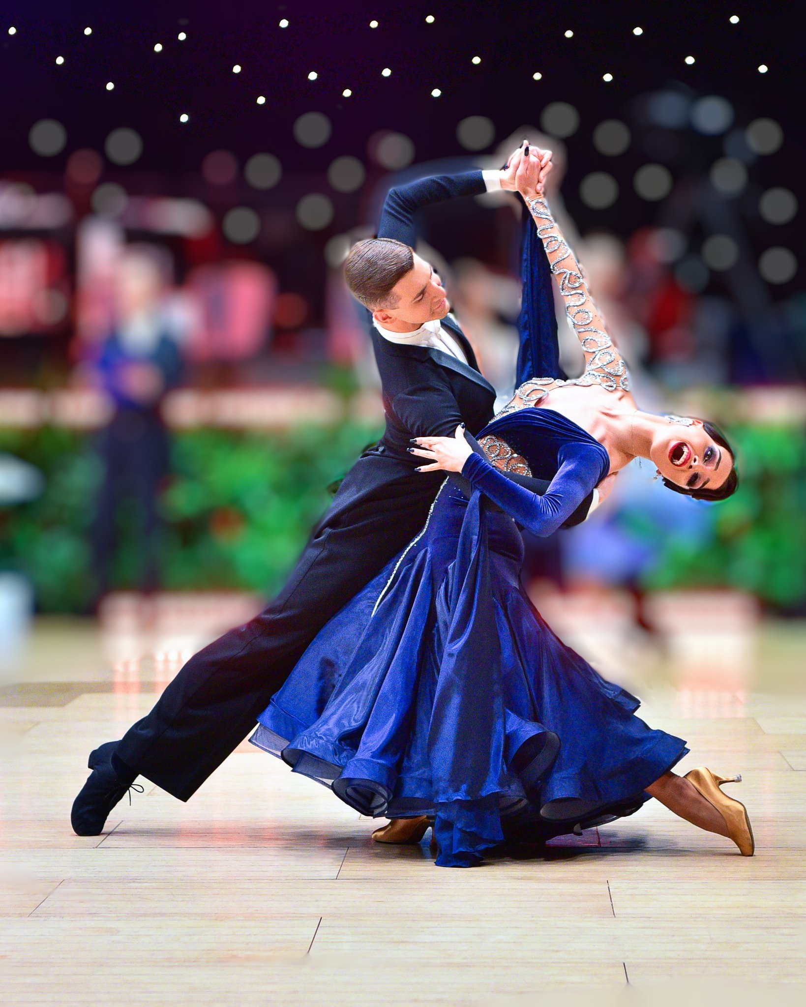 Para tancerzy tańcząca taniec towarzyski, kobieta w niebieskiej sukni z ozdobami, mężczyzna w czarnym smokingu, parkiet w tle