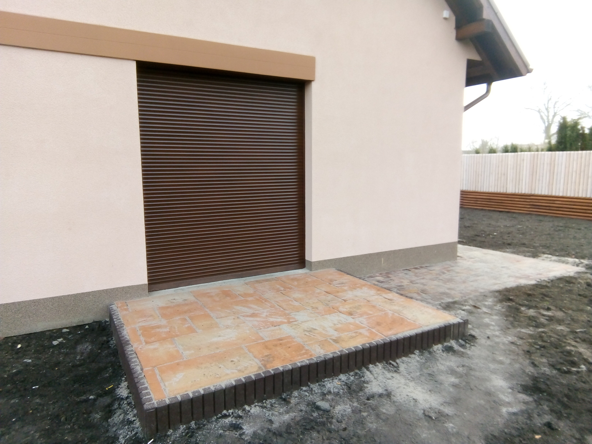 Mały taras z palisadą i płytką betonową dekoracyjną.