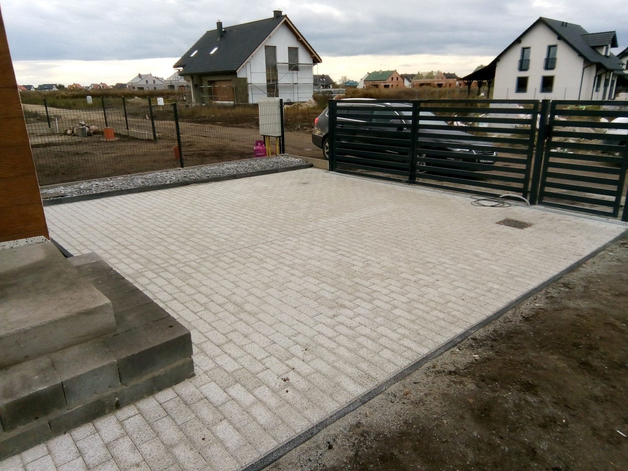 Podjazd na posesję z kostki betonowej dekoracyjnej.