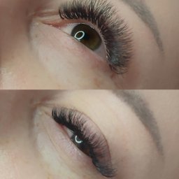 Pracownia Urody ARTIST Paulina Wójcik - Zbliżenie na dwa oczy z przedłużonymi, gęstymi, czarnymi rzęsami. Widoczne brwi o naturalnym kształcie i delikatnym makijażu. W odbiciu w źrenicy widoczny pierścień świetlny.