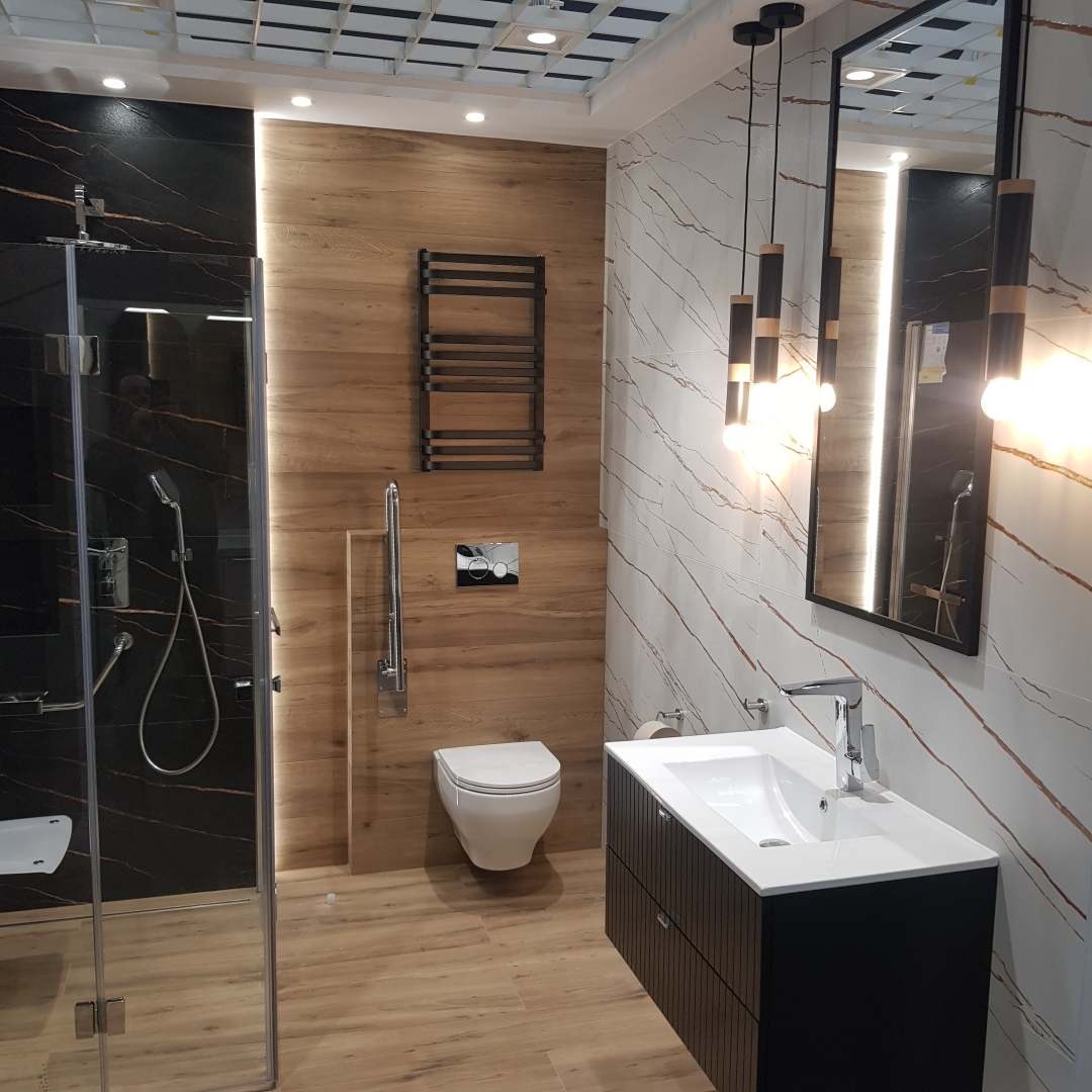 Nowoczesna łazienka z kabiną prysznicową typu walk-in, umywalką w szafce i podwieszaną toaletą. Ściany wykończone płytkami imitującymi drewno i marmur.