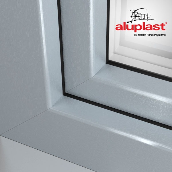 Fragment okna PCV marki Aluplast z widocznym logo w prawym górnym rogu, prezentujący detale profilu i uszczelki.