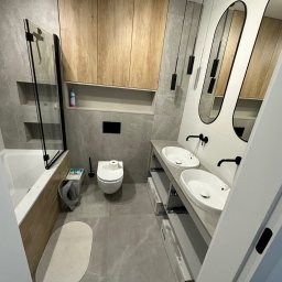 valentyn haliev - Nowoczesna łazienka z szarymi płytkami imitującymi marmur, drewnianymi szafkami wiszącymi, dwoma owalnymi umywalkami nablatowymi z czarną armaturą, podłużnymi lustrami w czarnych ramach i wiszącymi...