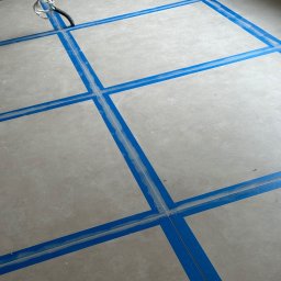 valentyn haliev - Przygotowanie podłoża pod wylewkę samopoziomującą z użyciem taśmy dylatacyjnej, widoczne wystające przewody elektryczne.