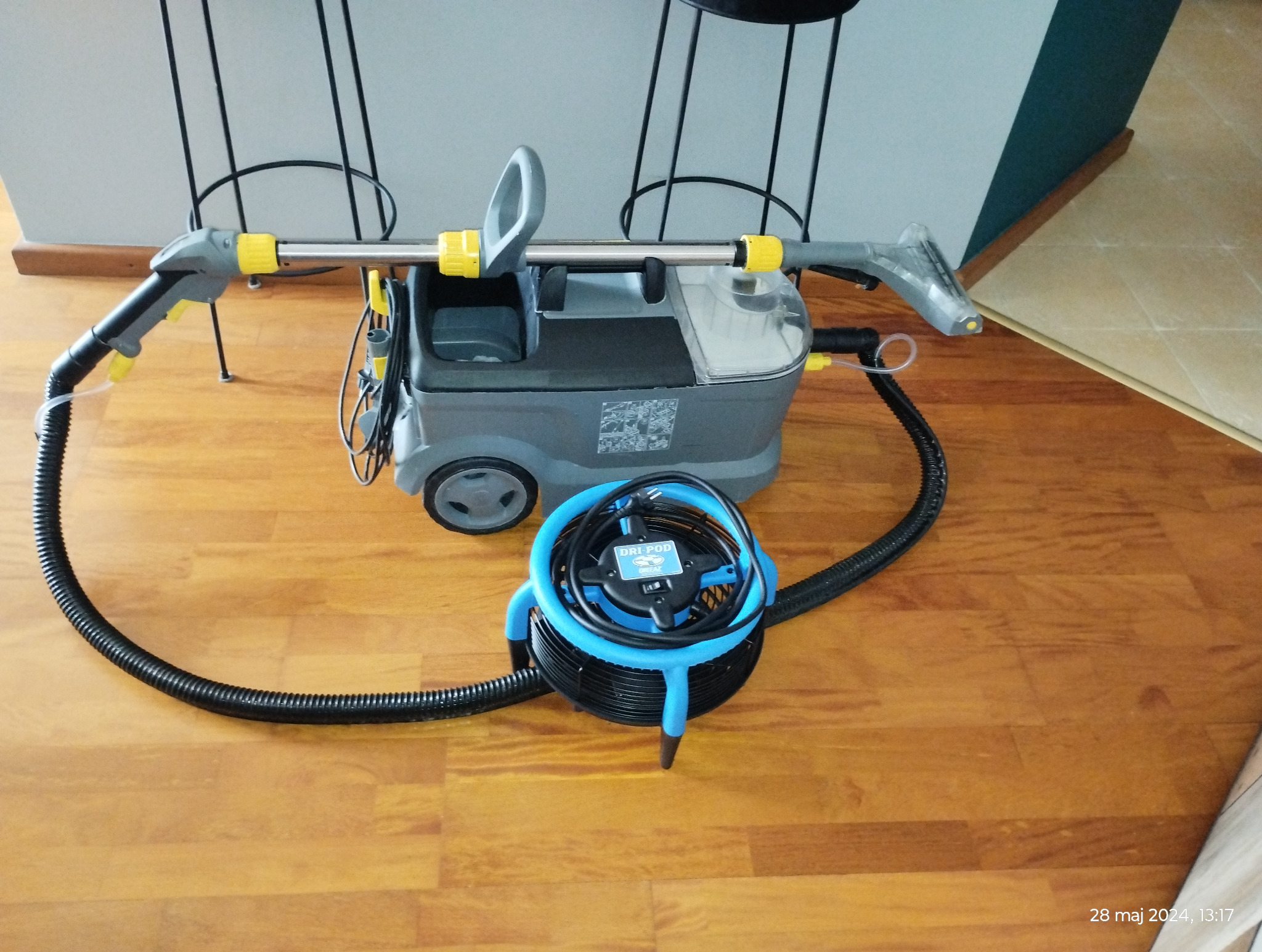 Profesjonalny odkurzacz piorący z akcesoriami, w tym suszarką Dri-Pod, na drewnianej podłodze, gotowy do użycia.