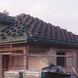 Dachiman - Dom w trakcie budowy, z przygotowaną konstrukcją i częściowo ułożoną dachówką ceramiczną marki Tondach, widoczne rusztowania.