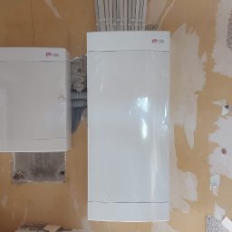 ELGRUPEL SPÓŁKA Z OGRANICZONĄ ODPOWIEDZIALNOŚCIĄ - Dwie białe skrzynki elektryczne marki ETI zamontowane na ścianie w trakcie remontu w Międzyrzecu Podlaskim, widoczne przewody elektryczne w peszlu i rurkach PCV.