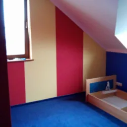 Pokój dziecięcy z pomalowanymi ścianami w pionowe pasy czerwieni i beżu oraz niebieską ścianą z oknem dachowym, na podłodze niebieska wykładzina, w rogu drewniane łóżko bez materaca.
