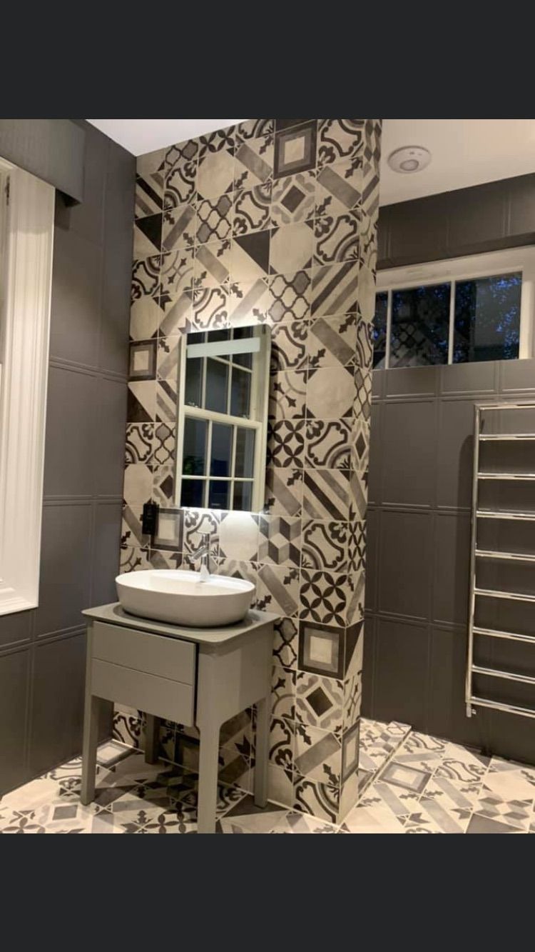 Szara łazienka z umywalką nablatową, wzorzystymi płytkami w stylu patchwork i grzejnikiem drabinkowym.