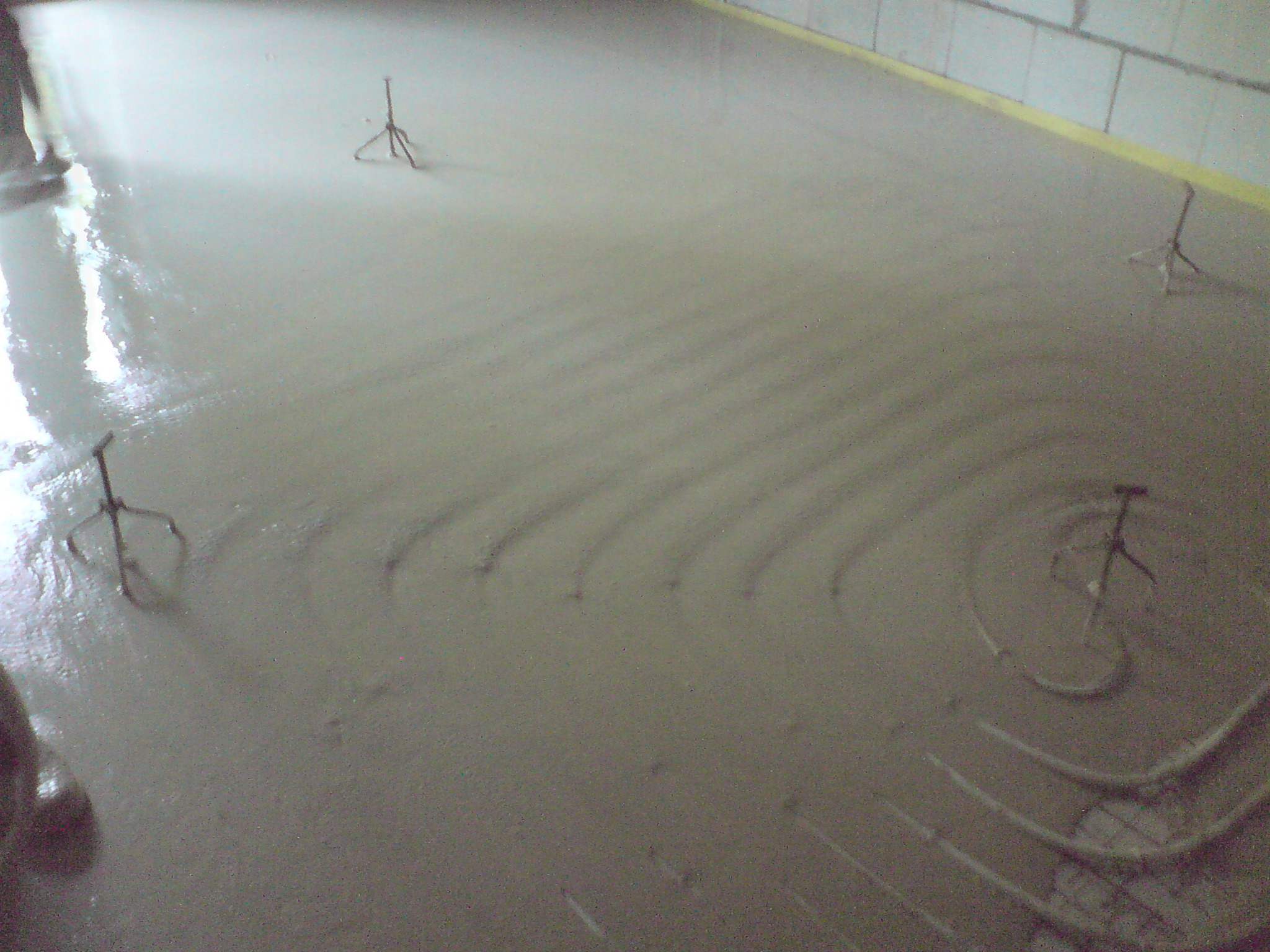 Wylewka samopoziomująca na ogrzewaniu podłogowym, widoczne ślady po rozprowadzaniu i uchwyty do mocowania rur.