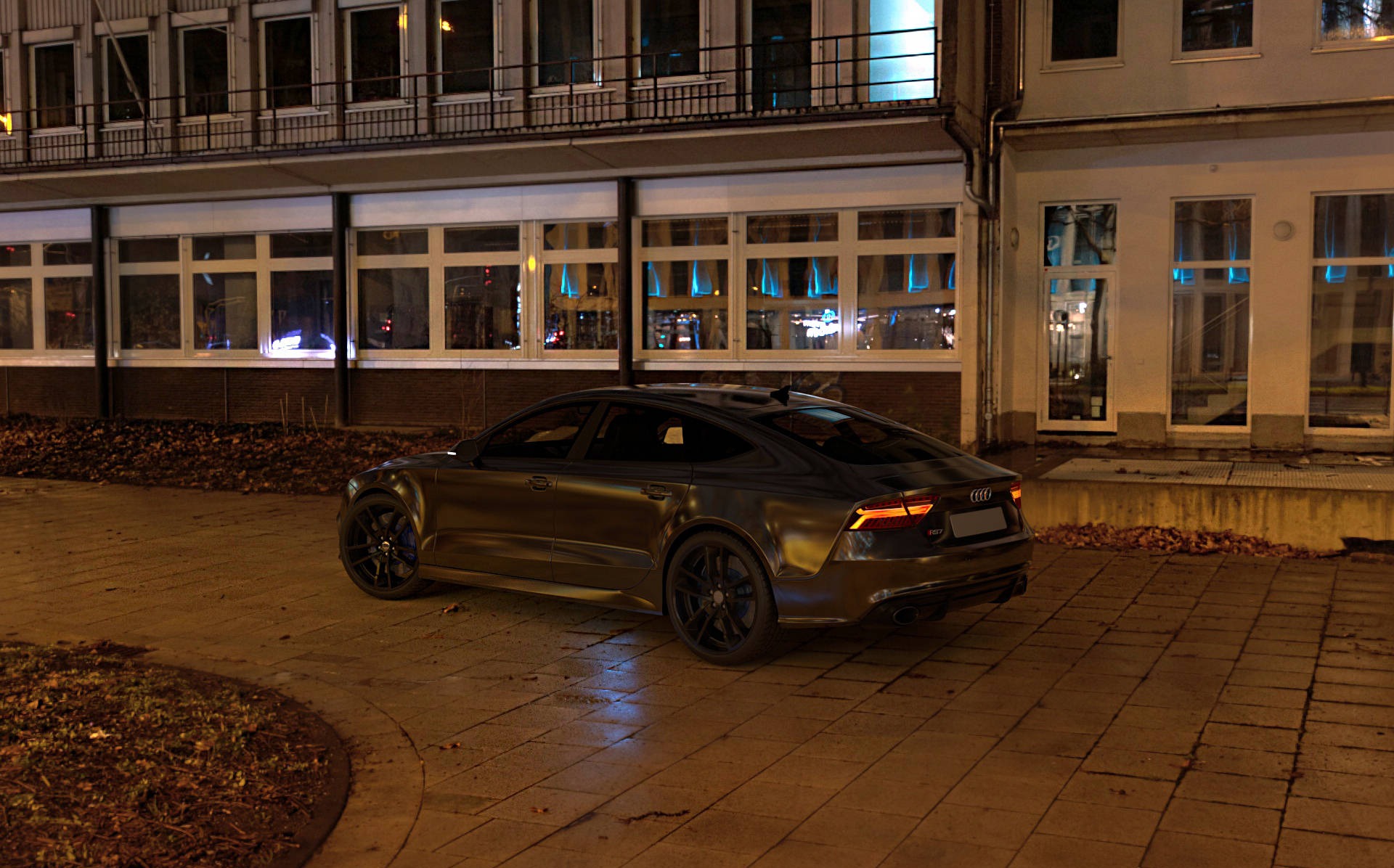 Ciemny, luksusowy samochód Audi A7 zaparkowany nocą na chodniku przed budynkiem z wieloma oknami, odbijającymi światła miasta.