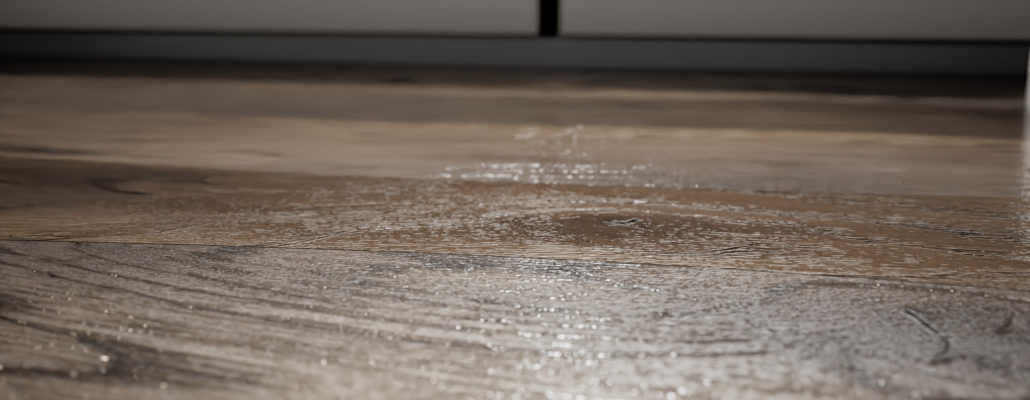 Zbliżenie na brązową podłogę z paneli imitujących drewno, widoczne delikatne refleksy światła i struktura drewna.