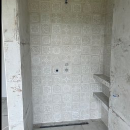 Adrian Pietrucha - Wykończona kabina prysznicowa w Grudnej Dolnej z dekoracyjnymi płytkami ściennymi i półkami, gotowa do montażu armatury. Minimalistyczny design.
