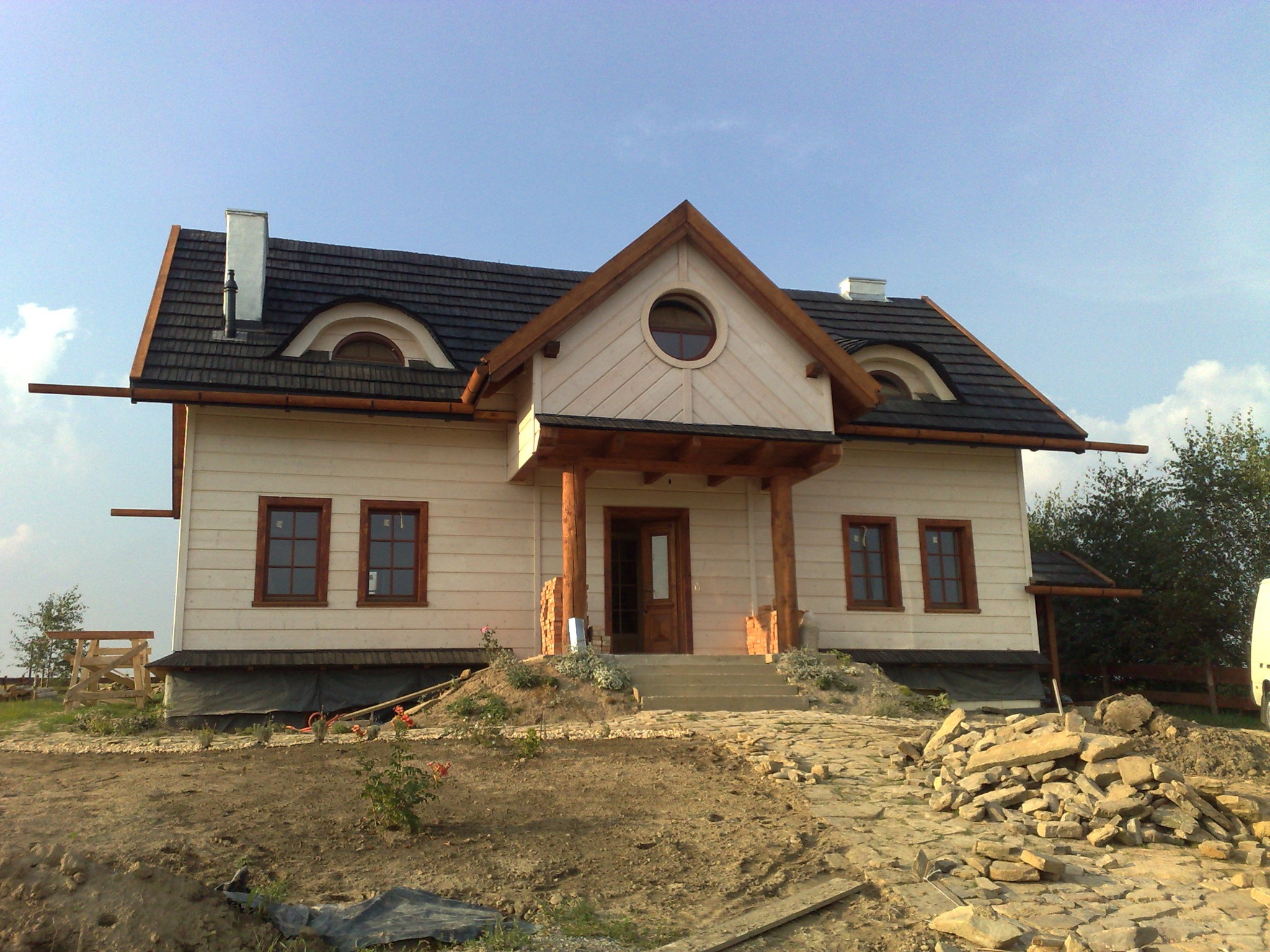 dom o konstrukcji szkieletowej wykończony deską elewacyjną , kryty gontem