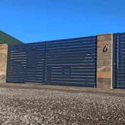 Nowoczesna brama wjazdowa z poziomych, szarych profili, osadzona na słupkach z bloków imitujących kamień, na tle zielonego dachu i błękitnego nieba.