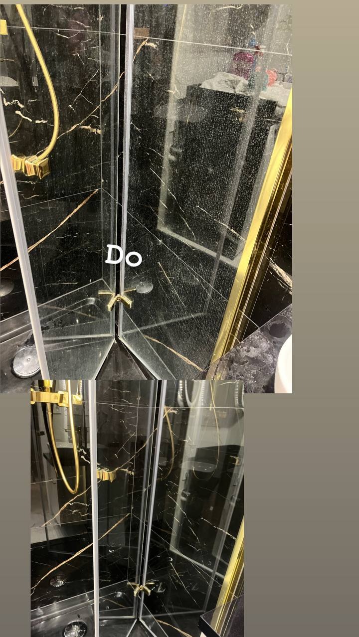Brudna kabina prysznicowa z czarnymi marmurowymi płytkami i złotymi elementami przed czyszczeniem, widoczne zacieki i osady na szklanych drzwiach.