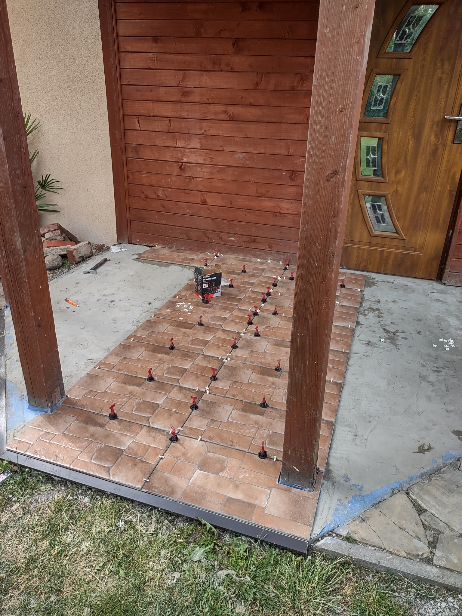 Wykonanie hydroizolacji, listew, spadku oraz ułożenie płytek na ganku