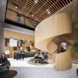 Wnętrze nowoczesnego holu z recepcją i spiralnymi schodami z jasnego drewna, widoczne osoby w różnych pozach, oświetlenie punktowe i dekoracyjne panele ścienne.