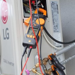 Strefa AC Sławomir Smoter - Serwisant w Rokicinach podhalańskich diagnozuje zewnętrzną jednostkę klimatyzacji LG Dual Inverter za pomocą multimetru cęgowego i termometru elektronicznego Testo 549i, sprawdzając parametry pracy...