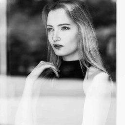 Paulina Wyszyńska-Górecka Photography & Marketing - Portret kobiety z długimi blond włosami, czarno-białe zdjęcie, skupiony wzrok, delikatny makijaż, pozuje przy oknie.