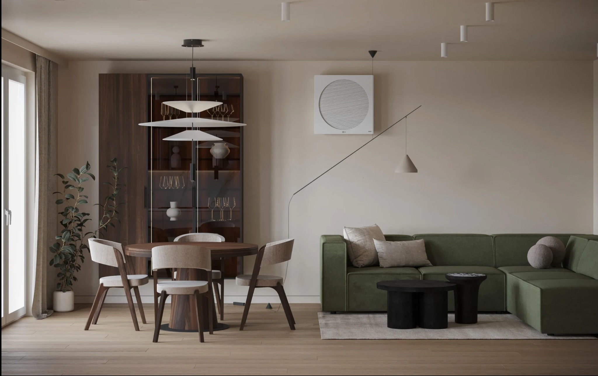 Nowoczesne wnętrze: okrągły stół z krzesłami, zielona sofa narożna, drewniana witryna z oświetleniem i dekoracjami, minimalistyczne lampy wiszące, jasna podłoga i ściany w odcieniach beżu.