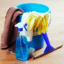 Tomex Usługi Porządkowe - Niebieskie wiadro z płynem, ściereczką, rękawicami i myjką do okien na drewnianej podłodze. Sprzęt do sprzątania w zbliżeniu, gotowy do użycia.