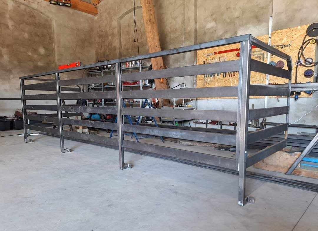 Surowa, spawana konstrukcja stalowa hali magazynowej w warsztacie, widoczne narzędzia i elementy wyposażenia w tle.