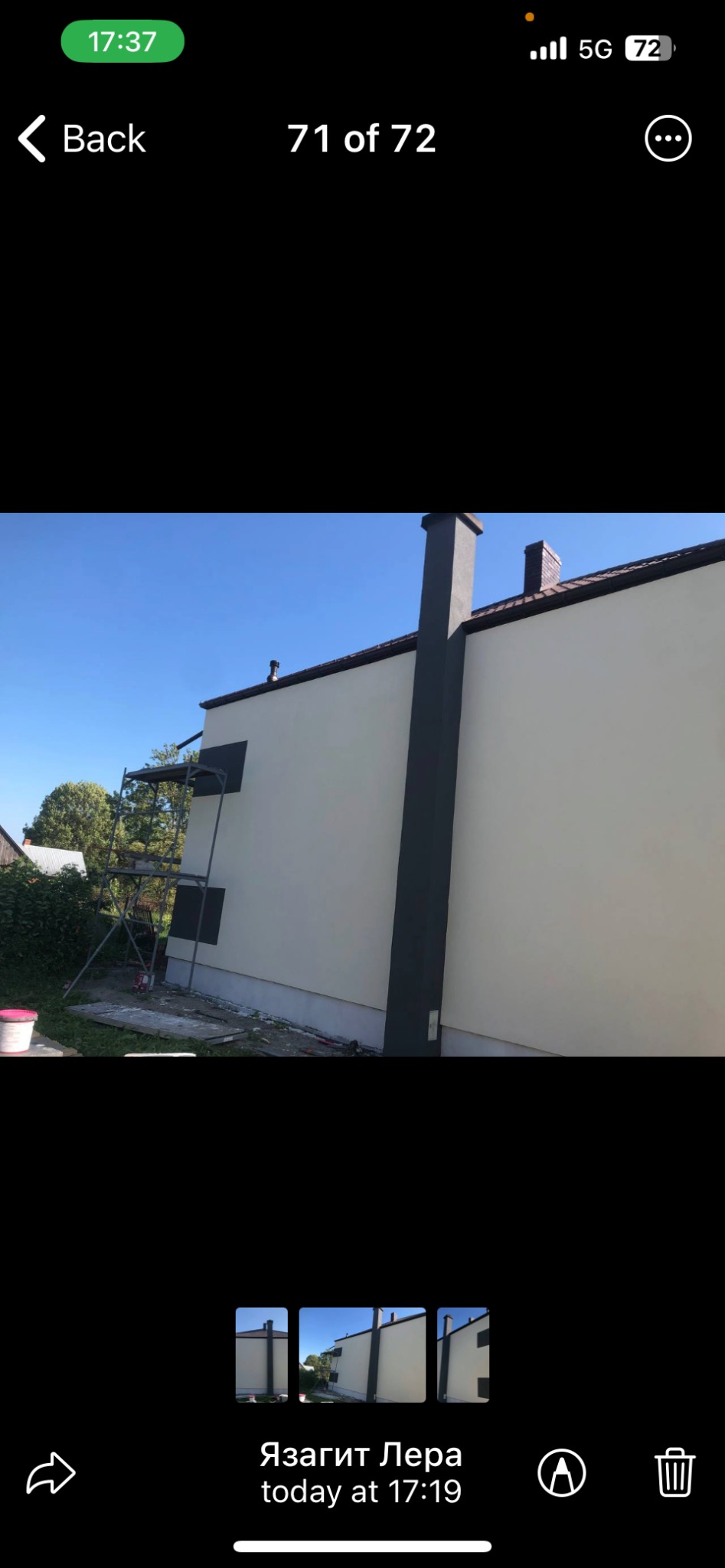 Elewacja budynku po malowaniu z ciemnym kominem i obramowaniami okien, widoczne rusztowanie i pozostałości farby na ziemi.