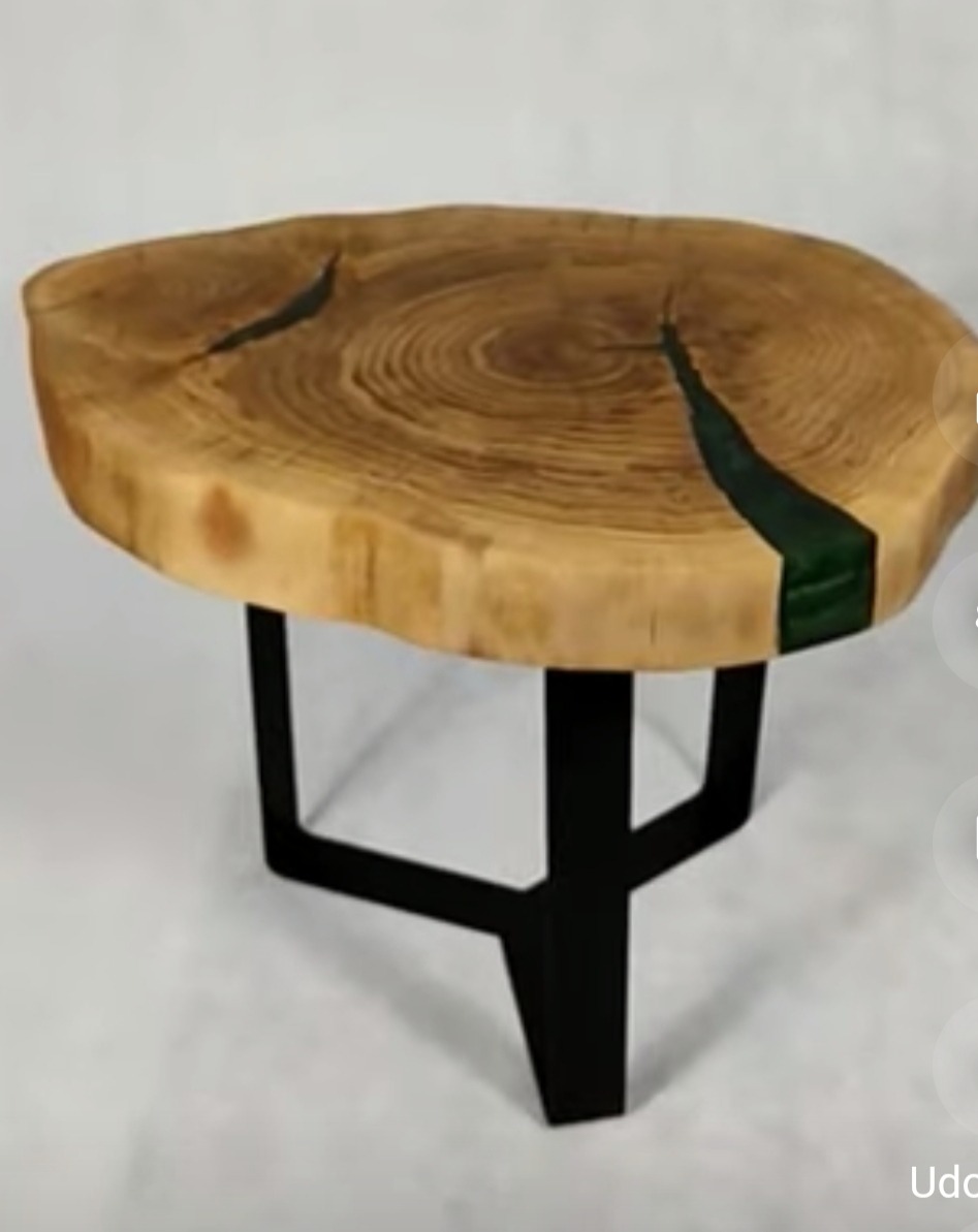 Stolik kawowy z blatem z plastra drewna z żywicą epoksydową w kolorze zielonym i czarnymi, metalowymi nogami.