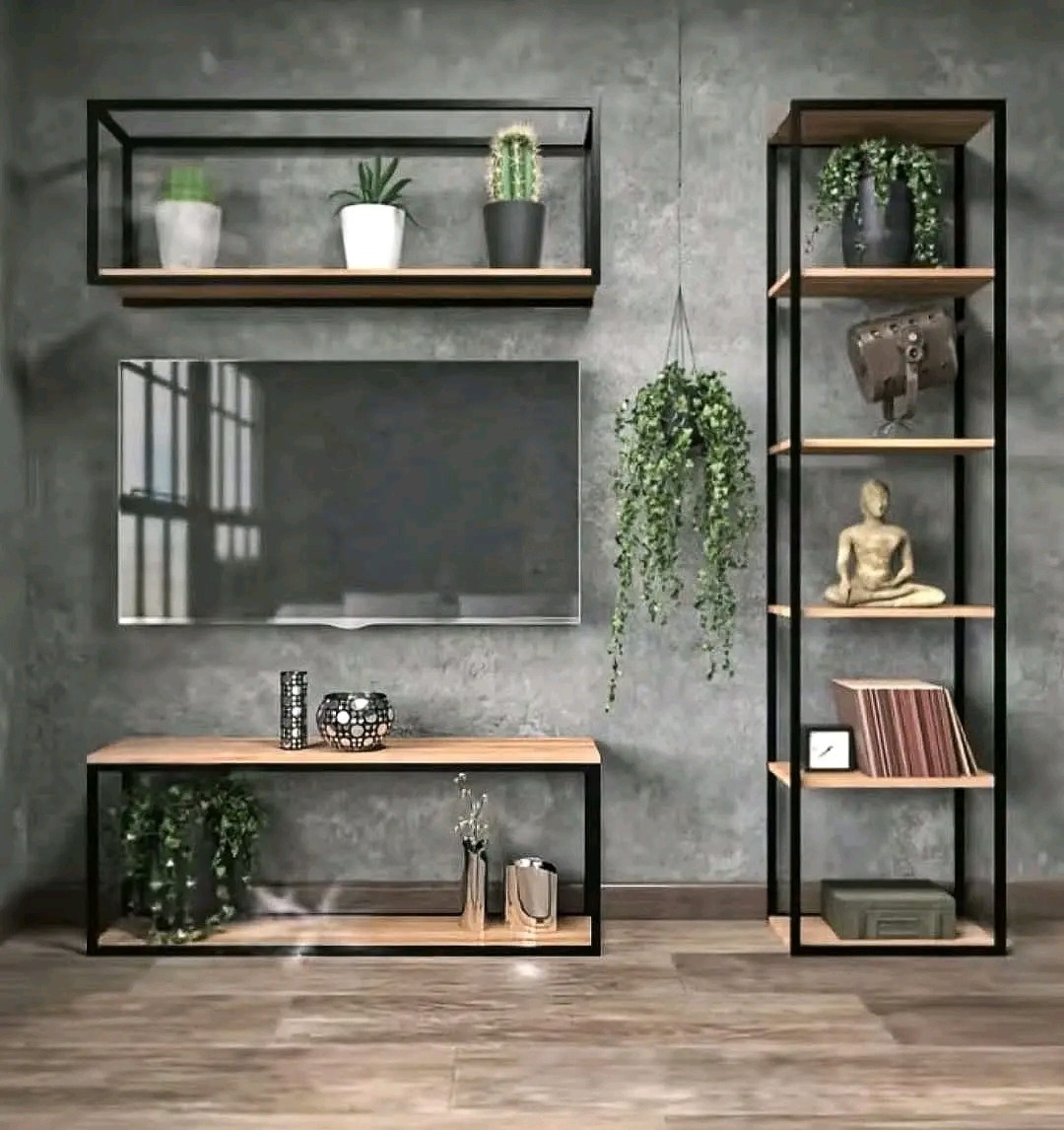 Loftowy zestaw mebli: półki wiszące, szafka RTV i regał z czarnymi metalowymi ramami i drewnianymi blatami, uzupełnione dekoracjami i roślinami na tle szarej ściany.