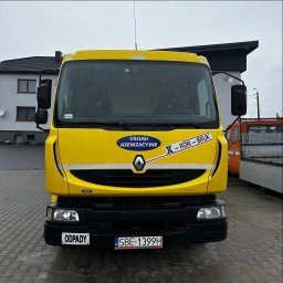 ROM-BRUK Usługi Brukarskie i Budowlane Gwóźdź Roman - Żółty samochód asenizacyjny marki Renault z naklejkami informującymi o usługach asenizacyjnych i nazwie firmy 'Rom-Bruk', zaparkowany na kostce brukowej przed budynkiem.