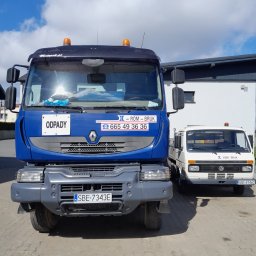 ROM-BRUK Usługi Brukarskie i Budowlane Gwóźdź Roman - Dwa samochody dostawcze firmy z Twardowic, jeden w kolorze niebieskim z tabliczką 'Odpady' i numerem telefonu, drugi biały, zaparkowane na brukowanym placu przed budynkiem.