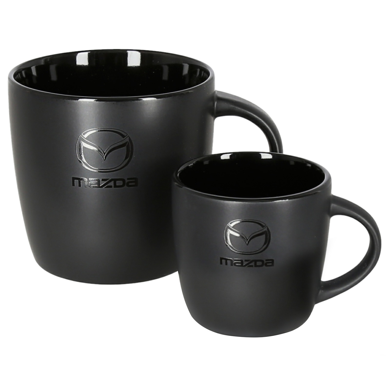 Dwa czarne kubki ceramiczne, jeden większy, drugi mniejszy, z logo i napisem Mazda, ustawione obok siebie na białym tle.