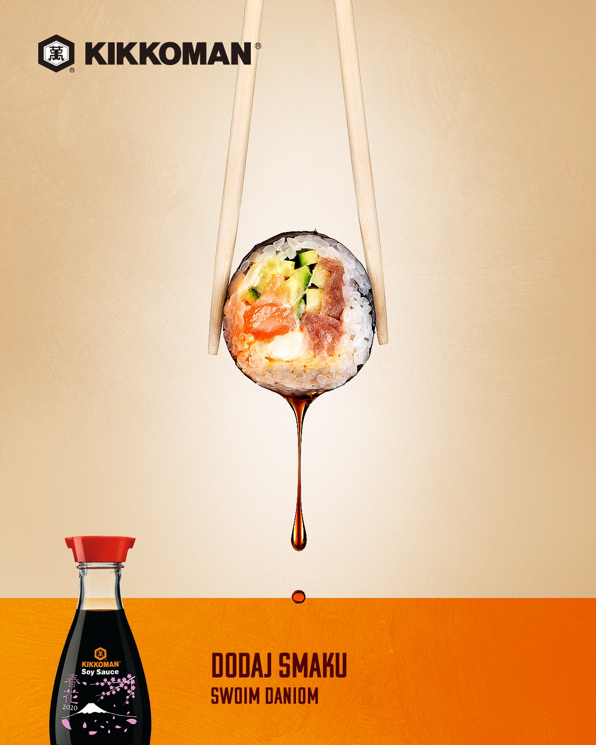 Sushi maki zawieszone w powietrzu między pałeczkami, kropla sosu sojowego opada w dół, w tle butelka sosu Kikkoman i napis 'Dodaj smaku swoim daniom'.